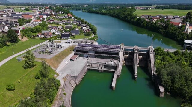 A hydropower plant is generating electricity using water and solar panels on its roof. This facility produces renewable energy.