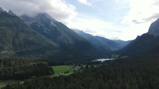 Aerial drone view of Hintersee lake near Ramsau bei Berchtesgaden in Bavaria, Germany, surrounded by dense coniferous forests and majestic Alpine mountains. Peaceful and scenic landscape