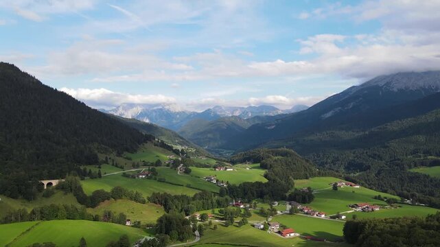 Aerial drone view of the idyllic Bavarian Alps near Ramsau bei Berchtesgaden, Germany, featuring lush green alpine meadows, narrow country roads and majestic mountain scenery. Peaceful rural landscape