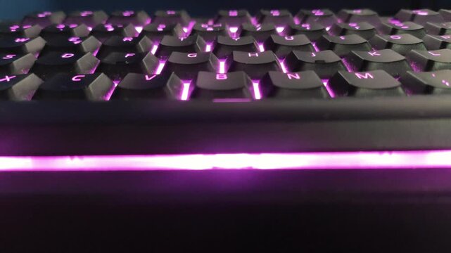 Close up of backlit gaming keyboard with dynamic color changing lighting effects.