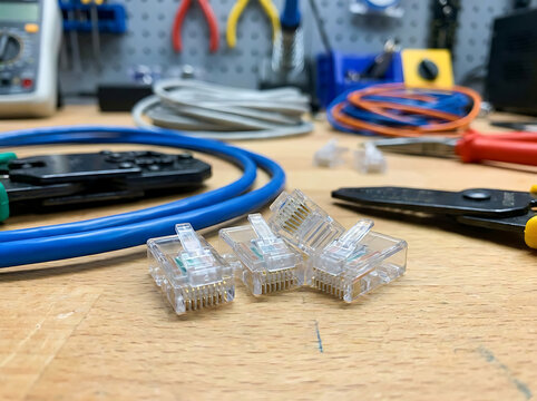 Network Cable Installation Tools and RJ45 Connectors on a Wooden Workbench for Ethernet Wiring