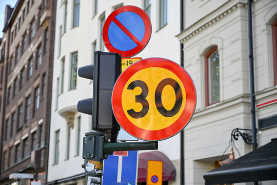 Maximum speed limit of 30 kilometers per hour sign in an urban area. Yellow traffic sign with a red border and number 30 for speed limit. Traffic sign indicating speed restriction in the city.