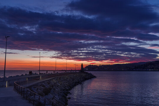 Clouds at sunset with cityscape silhouette, Imperia, Liguria region, Italy