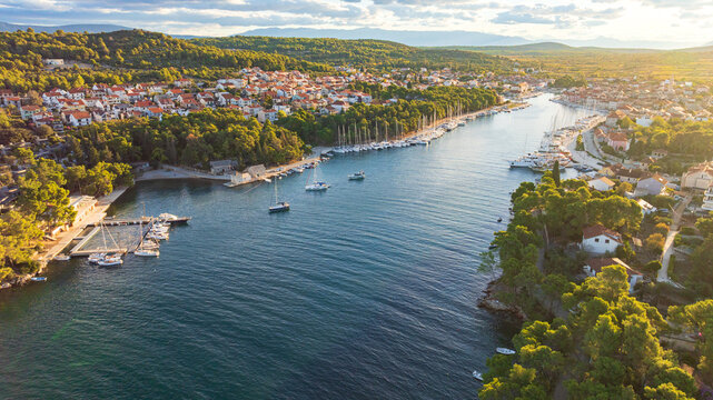 High angle drone shot displays stunning coastal landscape of Hvar Island. Panorama includes historic Stari Grad port