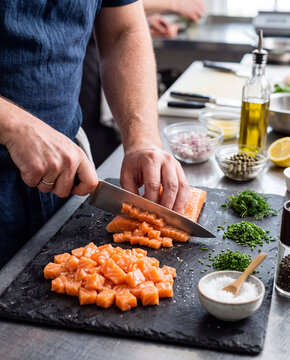 D&eacute;coupe d'un filet de saumon sur une planche &agrave; d&eacute;couper 