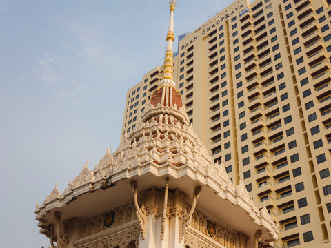 Structural and decorative details of Wat Che Chin Koh Chinese temple in Bangkok. Elegant pagoda elements, dragon carvings, and traditional architecture stand under clear sky.