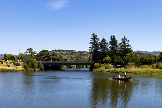 Scenic view of a gondola on the Napa River with bridge and trees.