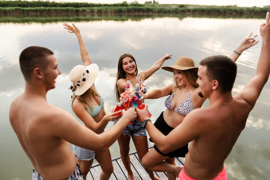 Friends Enjoy Summer by the River as They Celebrate and Raise Drinks