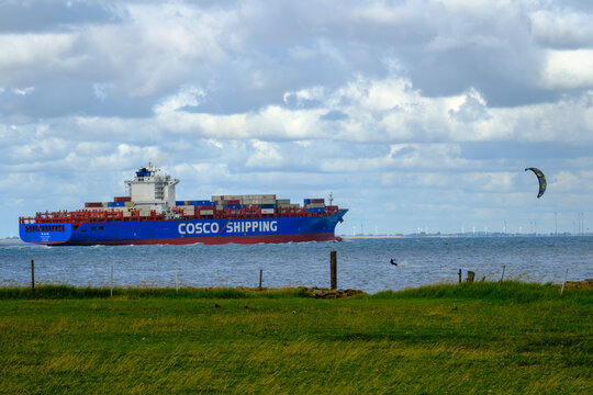 OTTERNDORF, DEUTSCHLAND &ndash; 10.08.2026: Das in  China registrierte Containerschiff XIN LIAN YUN GANG auf der Elbe in H&ouml;he OTTERNDORF. Im Vordergrund ein Kitesurfer auf der Elbe.