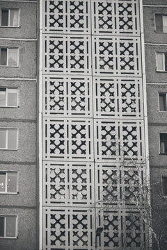 Black and white shot Soviet brutalist residential building with geometric patterned facade decor.