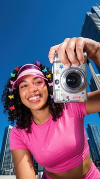 Woman camera selfie portrait smiling colorful headband pink shirt blue sky city building