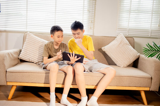 Two Brothers Using a Tablet Together at Home