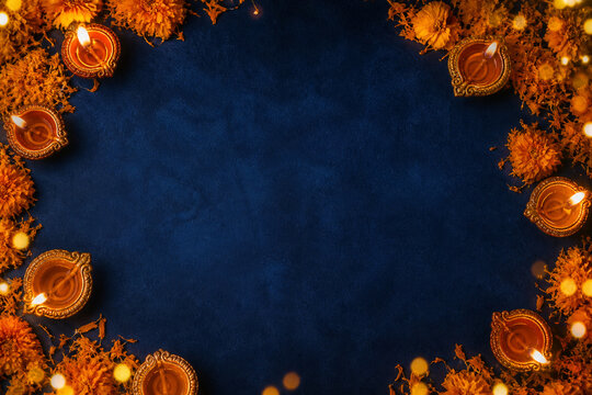 Diwali Celebration Border: A decorative border of illuminated diyas (oil lamps) and marigold flowers frames a dark blue textured background, evoking the spirit of the festival of lights.