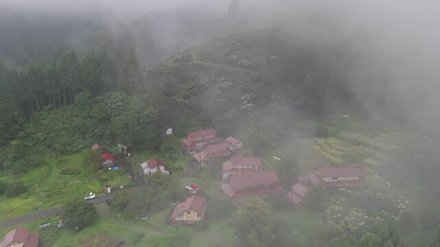 Aerial view of the historic Ozuchi village nestled in the misty mountains of the Kaga Higashitani Preservation District, Kaga, Ishikawa, Japan.