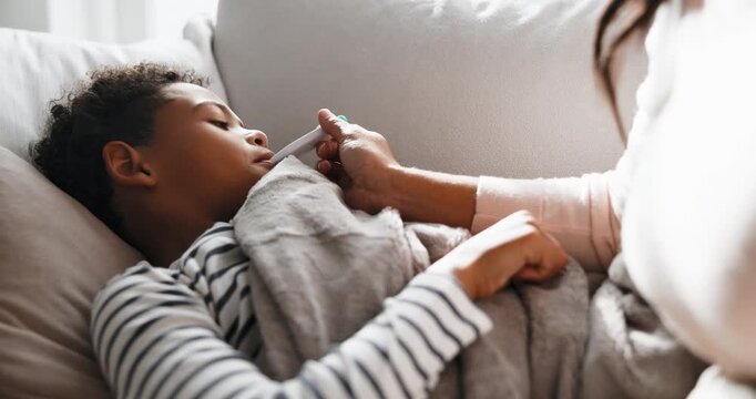 Sick, mom and kid in house with thermometer, childcare and health monitor with flu symptoms. Support, mother and child in home with tech, parenthood and temperature check in illness assessment.