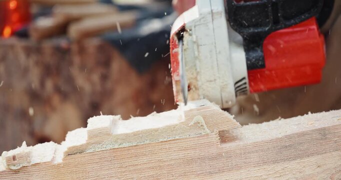Close up jigsaw saw cutting hardwood on workshop art workbench with handheld tracking movement in slow motion.