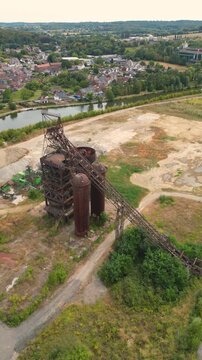 Aerial view of the abandoned Clabecq steelworks with rusty industrial structures and overgrown land in Tubize, Wallonia, Belgium.