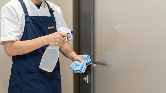 Japanese Restaurant Staff Disinfecting Door Handle, Copy space on the right