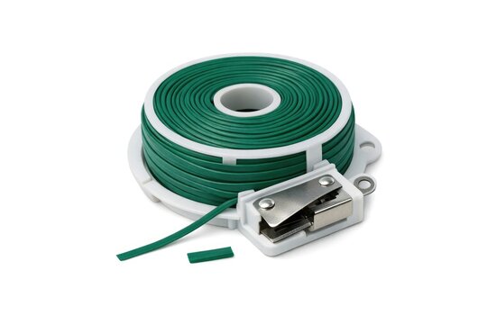 A close-up shot of a green and white cord and a stapler on a desk