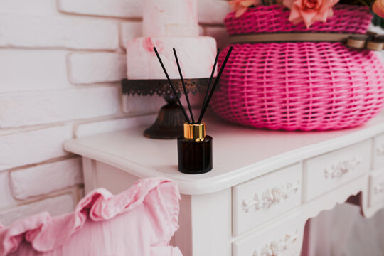 A diffuser is a means to eliminate unpleasant odors in the living room or office. On a shelf or coffee table in the living room there is a jar of dark glass with aromatic oil and synthetic sticks