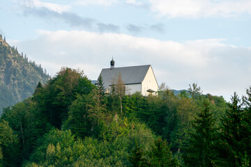 Fototapeta premium Historic Schöllang Burgkirche Church Surrounded by Forest in the Bavarian Allgäu