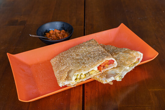 Brazilian pastel showcasing savory fillings on wooden background