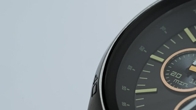 Extreme close-up of a modern black chronograph wristwatch isolated on a white background