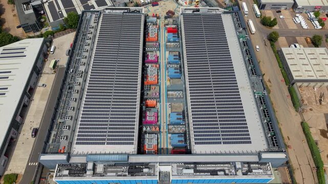Aerial view of the NTT 3 Data Center featuring extensive rooftop solar panels and industrial cooling infrastructure in Hemel Hempstead, England, United Kingdom.