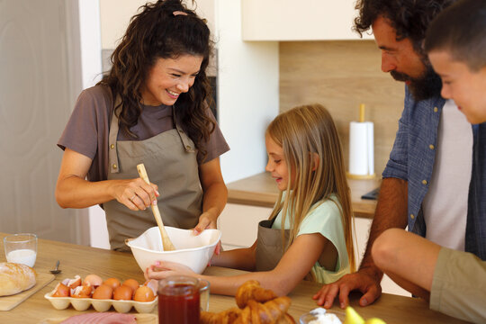 Mother and daughter preparing homemade food together in the family kitchen