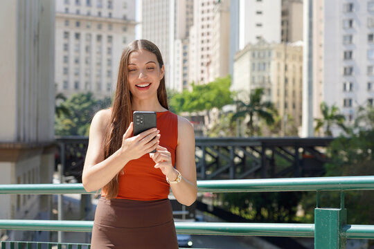 Portrait of Brazilian Business Woman Using Banking App on Mobile Phone in Sao Paulo City Street, Brazil
