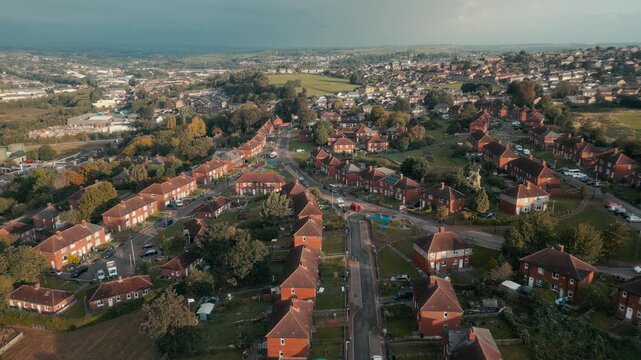 Red-tiled homes stretch in neat rows, framed by green fields