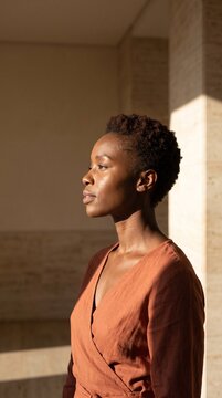 Profile portrait of a beautiful African American woman with short hair illuminated by warm natural sunlight