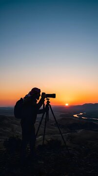 Silhouetted male photographer with tripod and telephoto lens