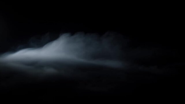 Dark fog cloud drifting through black background with soft blue gray light
