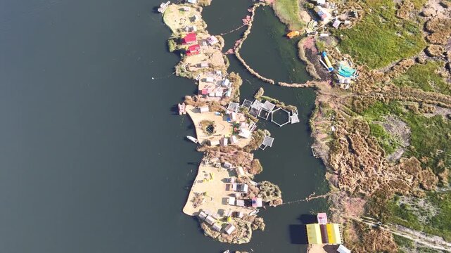 Overhead drone footage capturing the intricate layout of the Uros floating islands made of totora reeds in Peru.