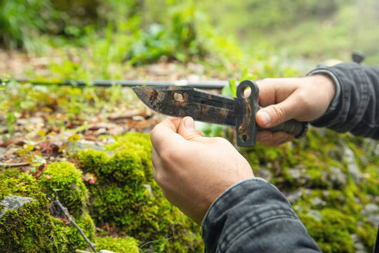Man using hunting knife in the forest.