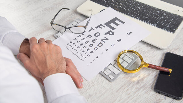 Caucasian doctor showing eye examination test in the workplace.