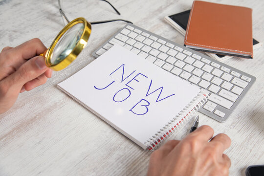 Man writes New Job message on notepad.