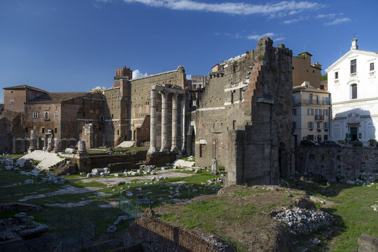 View of the ancient ruins of the Forum of Nerva with Corinthian columns and historic stone walls under a clear blue sky in Rome, Lazio, Italy.