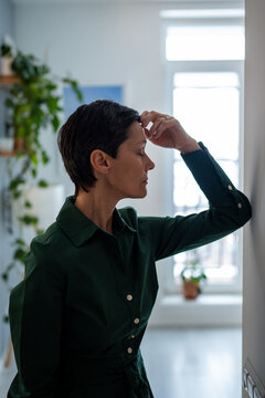 Tired hopeless mature woman leaning on wall in mental struggle and deep personal crisis. Emotional breakdown, overwhelming difficulties, mental health issues, turmoil suffering, feel pain and trapped
