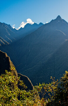 Peru, South America: crepuscular and god rays through the mountains and the lush vegetation of the 15th century Inca citadel of Machu Picchu, the Lost City of the Incas