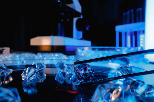 Closeup of lab diamonds and gemstone under microscope in laboratory for jewelry inspection and scientific
