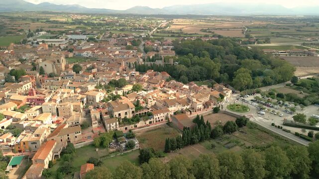 Aerial view of the historic town of Peralada with its traditional terracotta rooftops, stone buildings, and surrounding lush greenery in Peralada, Catalonia, Spain.
