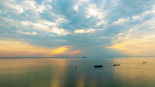 Hefei Chaohu Zhongmiao Sunset Tyndall Light Aerial Timelapse: Golden Rays Pierce Clouds Over Calm Waters with Solitary Boats at Dusk