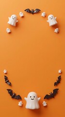 Fototapeta premium Cute little ghosts and black bats forming a frame on a bright orange background for halloween celebration