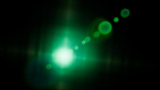 Bright green lens flare effect glowing against a dark background in digital format