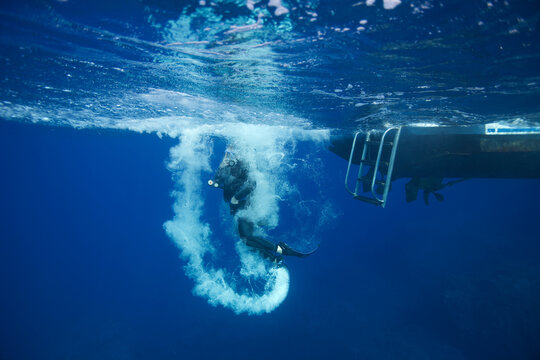 Diver entering the water from a boat