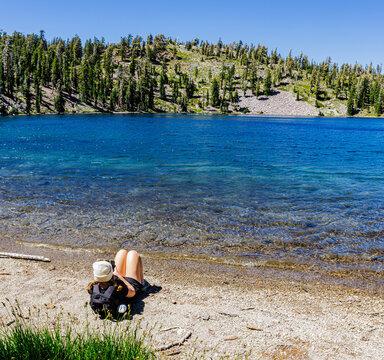 Young Female Hiker Enjoying The Beautiful Turquoise Waters of Shadow Lake on The Terrace, Shadow and Cliff Lakes Trail, Lassen Volcanic National Park, California, USA