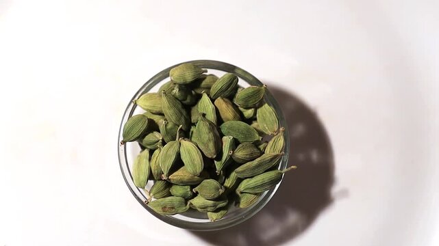 Cardamom in glass bowl table top view spin.