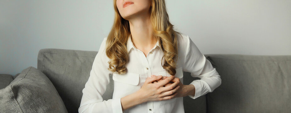 Unhealthy woman touching hands chest suffering from heart pain, feeling bad, heart health problems